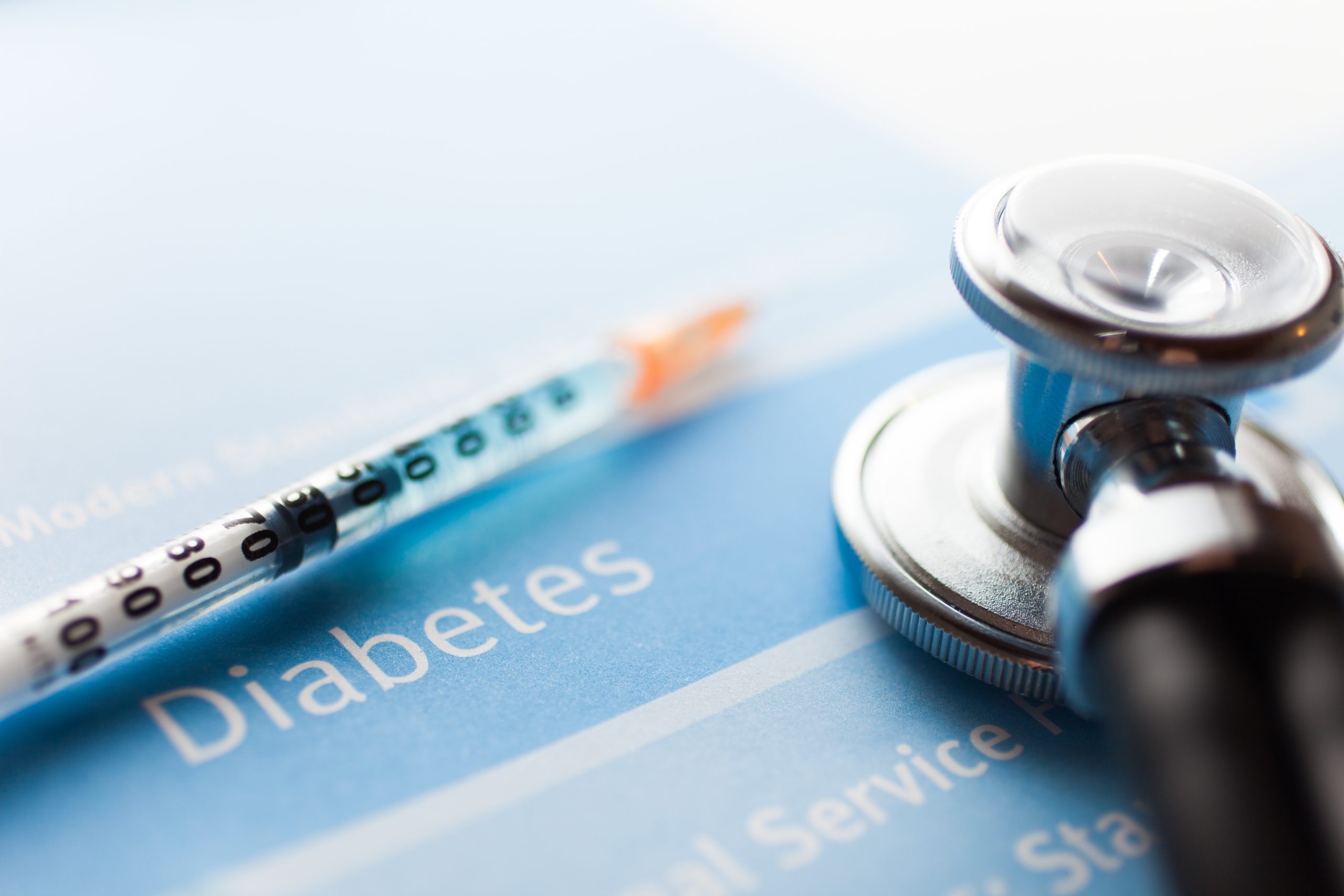 Diabetes mellitus A syringe and stethoscope on a blue paper labeled "Diabetes.